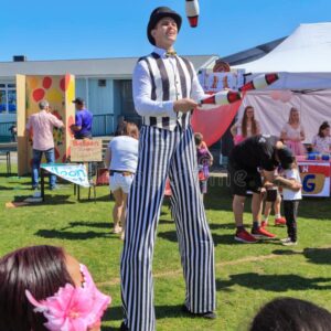 stilt-walker-juggling-clubs-fairground-male-stilt-walker-black-white-striped-costume-juggling-clubs-fair-159719329